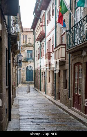 Typische Straßenszene der engen Gasse in der malerischen Stadt Guimares im Norden Portugals Stockfoto