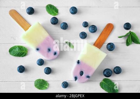 Hausgemachte Eiswürfel mit Heidelbeeren auf Holzhintergrund Stockfoto