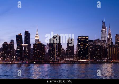 Abendansicht der Skyline von Manhattan mit Empire State, einem Vanderbilt und Chrysler-Gebäuden vom East River in New York City Stockfoto