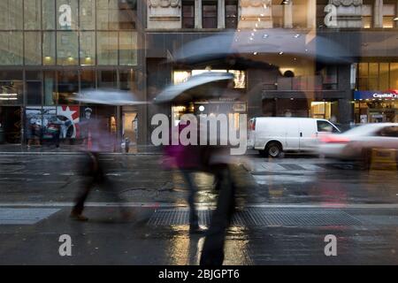 Fußgänger in Bewegung an einem launischen, regnerischen Tag in Lower Manhattan, New York City Stockfoto