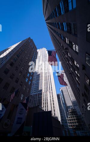 American Flags Blick auf die Art déco-Wolkenkratzer im Rockefeller Center in New York City Stockfoto