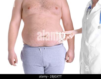 Ärztin, die das Fett auf dem Bauch des Mannes mit einem Messschieber auf weißem Hintergrund misst. Gewichtsverlust Konzept Stockfoto
