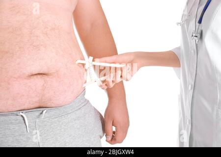 Weibliche Arzt Messung von Fett auf dem Bauch des Mannes mit einem Caliper auf weißem Hintergrund, Nahaufnahme. Gewichtsverlust Konzept Stockfoto