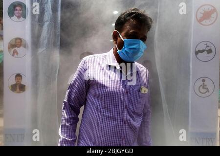 Kalkutta, Indien. April 2020. Indien: Die Menschen passieren die Desinfektionsmittel-Spritzkabine, die von der lokalen Behörde installiert wurde, während sie den lokalen Markt betreten. (Foto von Sudipta Pan/Pacific Press) Quelle: Pacific Press Agency/Alamy Live News Stockfoto