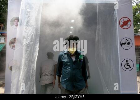 Kalkutta, Indien. April 2020. Indien: Die Menschen passieren die Desinfektionsmittel-Spritzkabine, die von der lokalen Behörde installiert wurde, während sie den lokalen Markt betreten. (Foto von Sudipta Pan/Pacific Press) Quelle: Pacific Press Agency/Alamy Live News Stockfoto