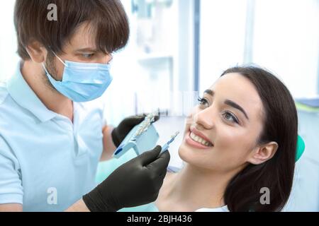 Zahnarzt Überprüfung und Auswahl der Farbe der Zähne in der Klinik Stockfoto