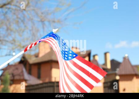 Winkende USA-Flagge und verschwommenes Haus auf Hintergrund Stockfoto