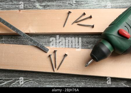 Schraub-Maschine, Lineal und Holzbretter auf Tisch in der Tischlerei Stockfoto