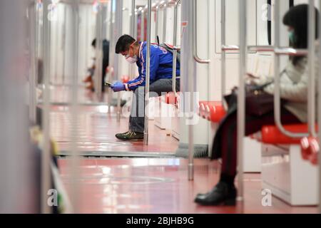 Rom. April 2020. Menschen mit Gesichtsmasken fahren in Mailand, Italien, am 29. April 2020 mit der U-Bahn. Soziale Distanz wird in den U-Bahn-Zügen in Mailand gefördert. Kredit: Xinhua/Alamy Live News Stockfoto