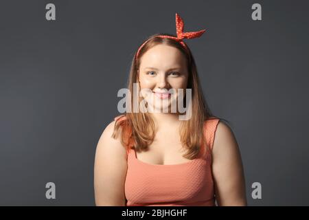 Übergewichtige junge Frau auf grauem Hintergrund. Diät-Konzept Stockfoto