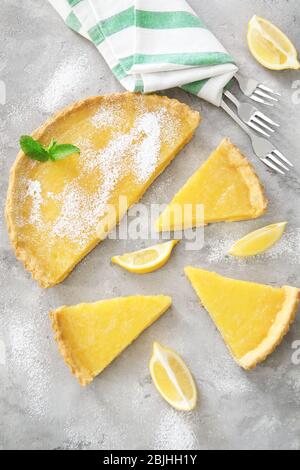 Zusammensetzung von geschnittenen Zitronenkuchen mit Besteck auf dem Tisch Stockfoto