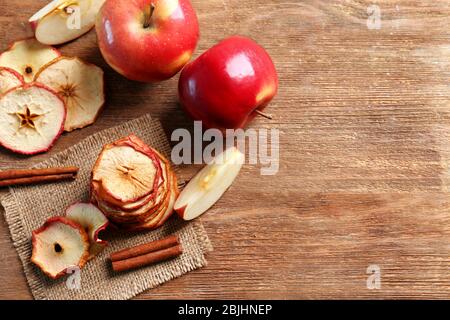 Komposition mit leckeren Apfelchips und Zimt auf Holztisch Stockfoto