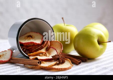 Komposition mit leckeren Apfelchips und Zimt auf dem Tisch, Nahaufnahme Stockfoto