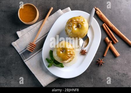 Komposition mit leckeren gebackenen Äpfeln und Zimt auf grauem Tisch Stockfoto