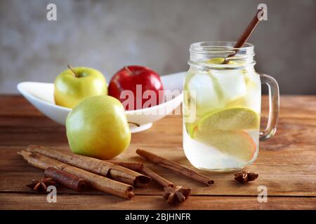 Mason-Glas mit frischem Apfelwasser und Zimt auf Holztisch Stockfoto