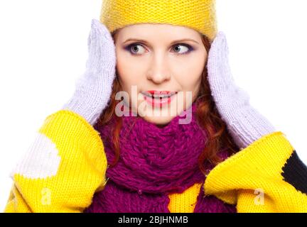 Junge Frau in Winterkleidung auf weißem Hintergrund mit Händen in der Nähe des Gesichts Stockfoto