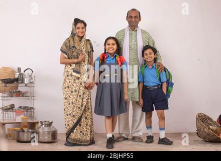 Indische Eltern und ihre beiden Kinder stehen vor der Tür Stockfoto