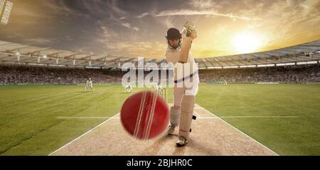 Ein junger Sportler spielt Cricket mit Haltung des Schlagens der Ball Stockfoto