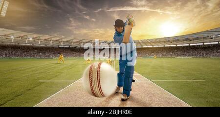 Ein junger Sportler spielt Cricket mit Haltung des Schlagens der Ball Stockfoto