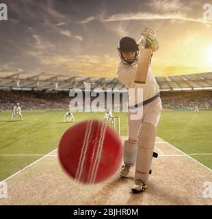 Ein junger Sportler spielt Cricket mit Haltung des Schlagens der Ball Stockfoto