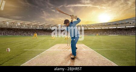 Der junge Sportler schlägt den Ball beim Schlagstock auf dem Cricket-Feld Stockfoto