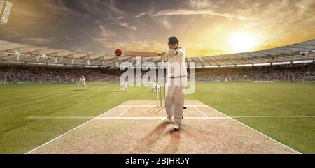 Junger Sportler, der beim Bitting auf dem Cricket-Feld den Ball schlägt Stockfoto