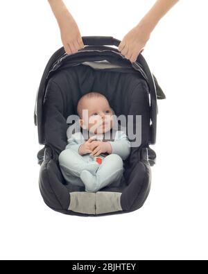 Hände halten liebenswert Baby im Autositz auf weißem Hintergrund Stockfoto