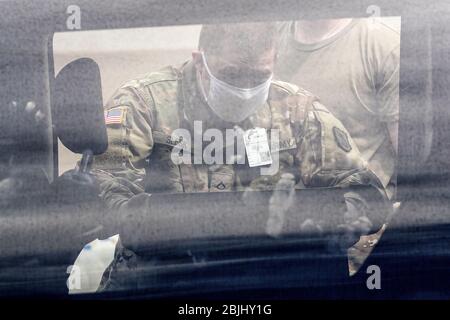 Private First Class Jake Slesk von der Washington National Guard verteilt kostenlose Nahrung an Bewohner unter staatlich auferlegten Aufenthalt-zu-Hause-Aufträge während der Stockfoto