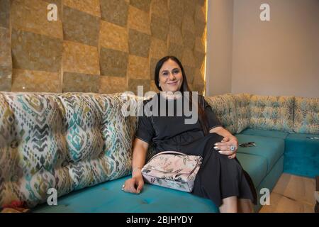 Porträt einer Frau, die bequem auf der Couch sitzt. Stockfoto