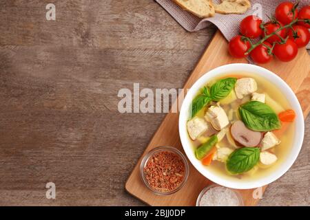 Komposition mit hausgemachter putensuppe in Schale auf Holztisch Stockfoto