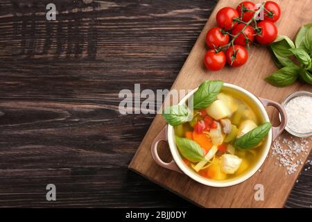 Komposition mit hausgemachter putensuppe in Auflauf auf Holztisch Stockfoto