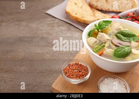 Komposition mit hausgemachter putensuppe in Schale auf Holztisch Stockfoto