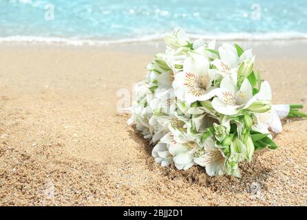 Schöner Strauß auf Sand. Hochzeitskonzept am Strand Stockfoto