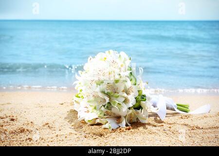 Schöner Strauß auf Sand. Hochzeitskonzept am Strand Stockfoto