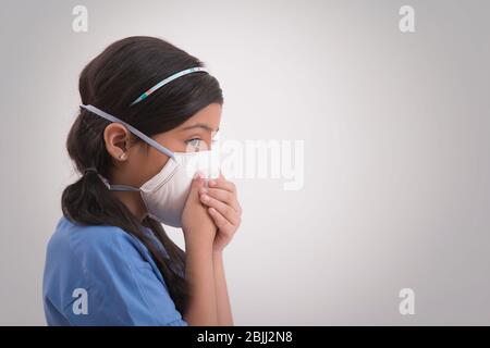 Junges Mädchen trägt Umweltverschmutzung Maske und bedeckt ihre Nase. (Kinder) Stockfoto