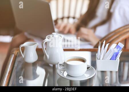 Tasse leckeren heißen Kaffee, Zucker und Milchkännchen auf dem Tisch im Café Stockfoto