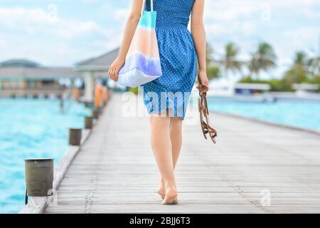 Schöne junge Frau, die entlang Ponton am Meer Resort Stockfoto