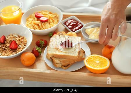 Junge schöne Frau mit Frühstück auf dem Bett Stockfoto