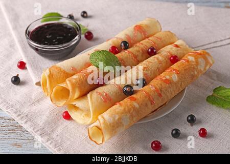 Leckere Pfannkuchen mit Johannisbeer-Marmelade auf dem Teller Stockfoto