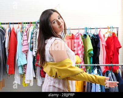 Schöne übergewichtige Frau versucht, auf kleine Jacke im Geschäft setzen Stockfoto