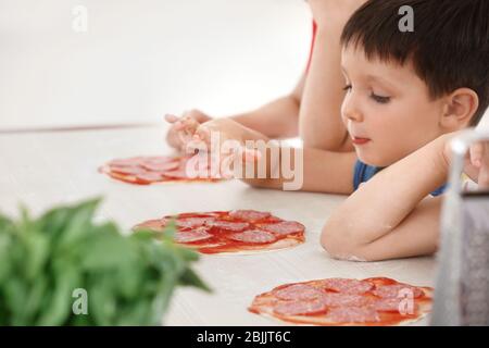 Nette Kinder in der Küche während Kochkursen Stockfoto