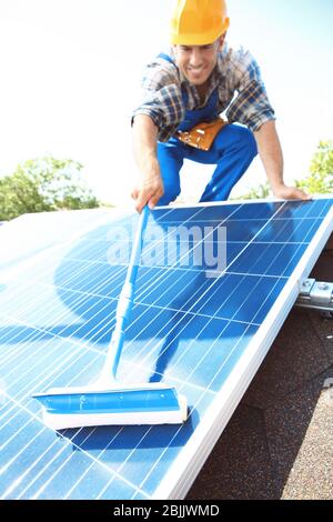 Arbeiter Reinigung von Solarpaneelen nach der Installation im Freien Stockfoto