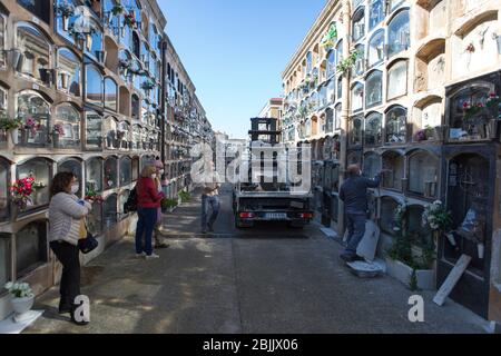 Barcelona, Spanien. April 2020. Bestatter, die den Sarg während der Beerdigung in die Nische stecken.Tochter, ihr Mann und eine Freundin entlassen Ernestina, die ein Opfer von Covid-19 war. Sechs Wochen nach der Verordnung über den Alarmzustand sind Beerdigungen immer noch verboten. In Barcelona sind nur drei Personen zu Beerdigungen zugelassen. Quelle: SOPA Images Limited/Alamy Live News Stockfoto