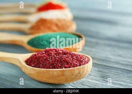 Verschiedene bunte Superfood Pulver in Löffeln auf Holztisch Stockfoto