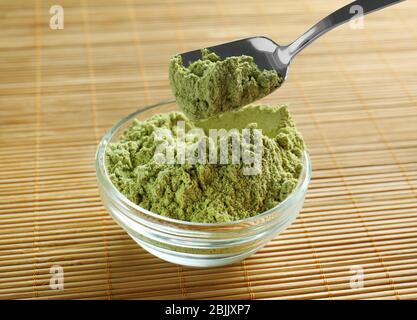 Superfood Pulver in Schüssel und Löffel auf dem Tisch Stockfoto