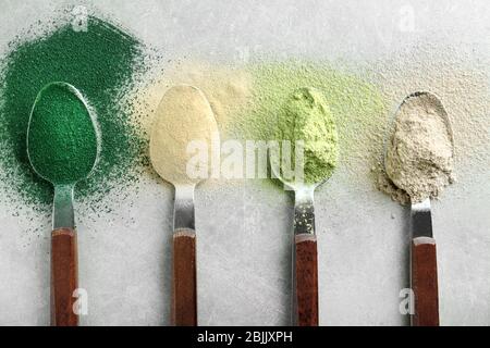 Verschiedene bunte Superfood Pulver in Löffeln auf dem Tisch Stockfoto