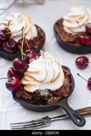 Mini-Torten in Eisenkernen mit Oreo-Keksteig, Schokoladenfüllung, Schlagsahne und frischen Beeren. Stockfoto