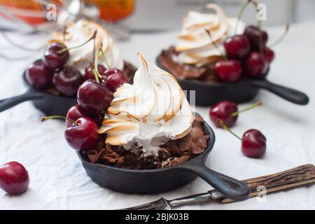 Mini-Torten in Eisenkernen mit Oreo-Keksteig, Schokoladenfüllung, Schlagsahne und frischen Beeren. Stockfoto