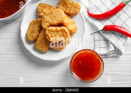 Hähnchennuggets mit Chilisauce auf Holztisch serviert Stockfoto