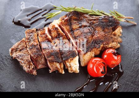 Leckeres gegrilltes Steak mit Rosmarin auf Schieferplatte Stockfoto